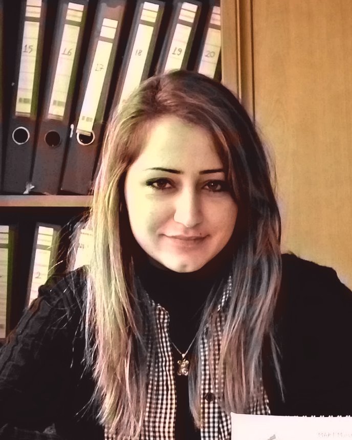 Gamze Arkoc at her desk in front of shelves of client files