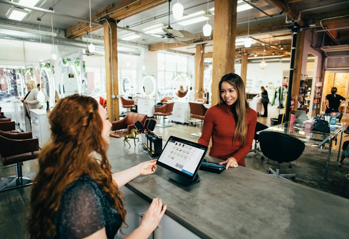 Small business owner serving a customer with a tablet till